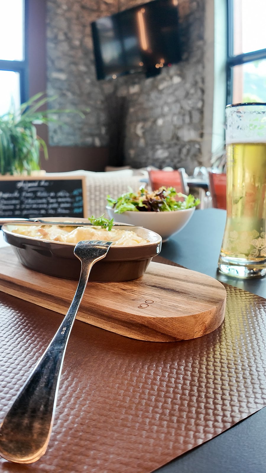 Gratin sur table avec bière et salade